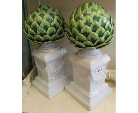 A pair of small decorative ceramic columns, featuring opening buds