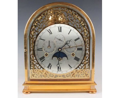 A modern gilt lacquered brass and bevelled glass calendar mantel clock with eight day three train movement chiming on eight b