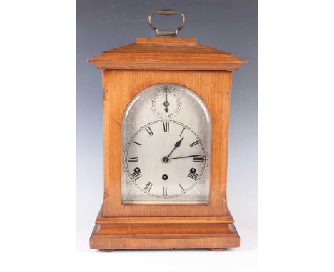 An early 20th century German walnut mantel clock with eight day movement striking and chiming on gongs, the silvered dial wit