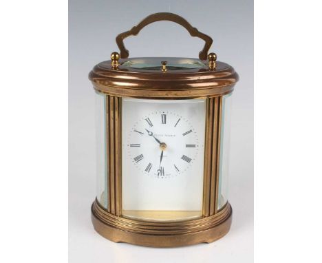 A modern large gilt lacquered brass oval cased carriage clock with eight day movement striking hours and half hours and repea