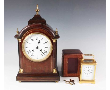 An Edwardian mahogany mantel clock with eight day movement striking on a gong, the circular white enamelled dial with black R
