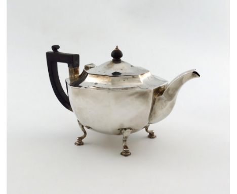 A silver teapot, by Charles Boyton and Sons, London 1921, octagonal panelled form, scroll handle, on four scroll feet, length