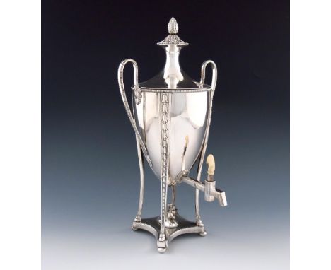 λ A George III old Sheffield plated tea urn, circa 1780, urn shape, beaded loop handles, the pull-off cover with a foliate co