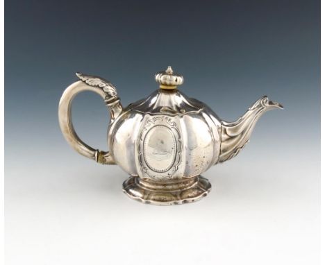 λ A George IV silver bachelor's teapot, by William Bateman, London 1820, lobed circular form, leaf capped scroll handle, dome