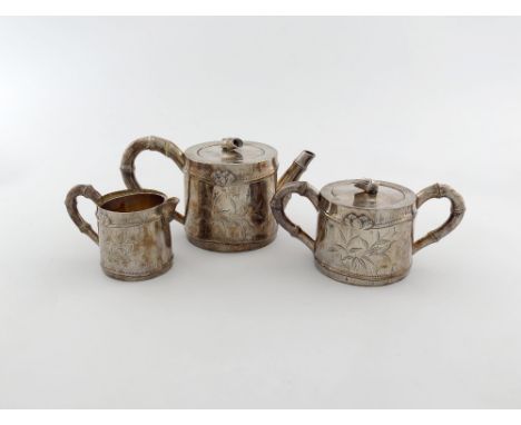 λ A three-piece Chinese silver tea set, marked to the base with Chinese characters, circular form, engraved with bamboo decor