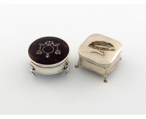 λ A silver trinket box, Birmingham 1910, rounded square form, the hinged cover with a mother-of-pearl flower, on four scroll 