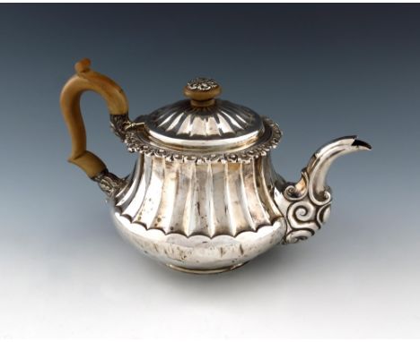 A George IV silver teapot, by Joseph Angell, London 1823, tapering circular bellied form, fluted decoration, foliate scroll b