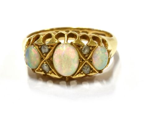 EDWARDIAN OPAL AND DIAMOND RING  Three solid white opal oval cabochons, showing bright play of colour, belcher claw set, alte