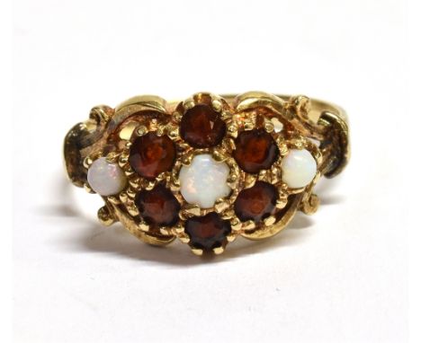 GARNET &amp; WHITE OPAL DRESS RING  In 9ct gold, 10.7mm wide floral cluster, set with round cabochon white opals and pyrope g