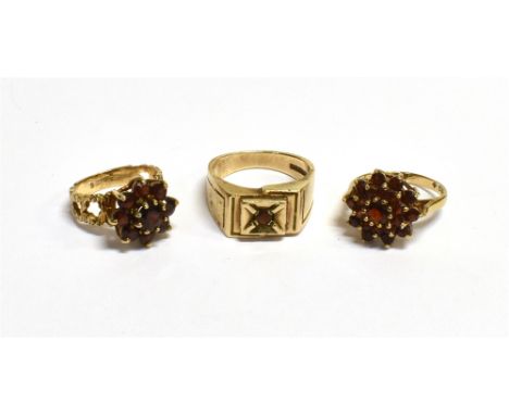 9CT GOLD &amp; GARNET SET RINGS  To include two tiered claw set clusters, set with round cut pyrope garnets, and one box grai