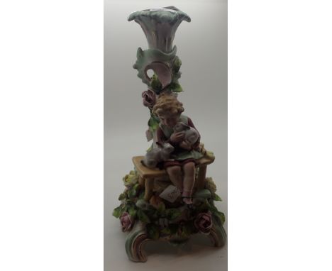 Continental porcelain candlestick featuring a child sitting on a bench with two rabbits surrounded by roses CONDITION REPORT: