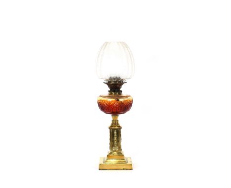 An early 20th Century brass column oil lamp, having cut glass font and etched shade, 67cm high
