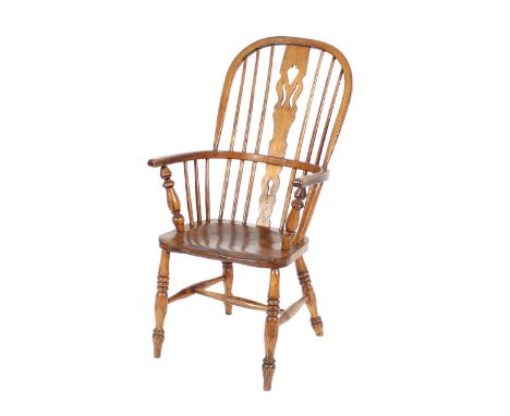 A 19th Century elm seated stick back Windsor chair, having pierced central splat, raised on ring turned supports united by an