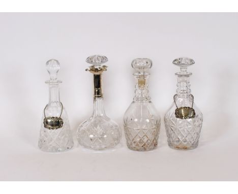 A cut glass decanter, with star and hobnail decoration, mounted with a silver collar; a pair of cut glass triple ring neck de