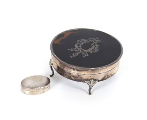 A circular silver and tortoise shell mounted trinket box, raised on shaped supports, London 1919; and a small oval silver snu