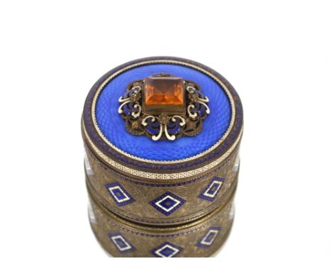 A Continental gilded metal and glass circular powder box and cover, decorated in blue enamel with filigree work and a central