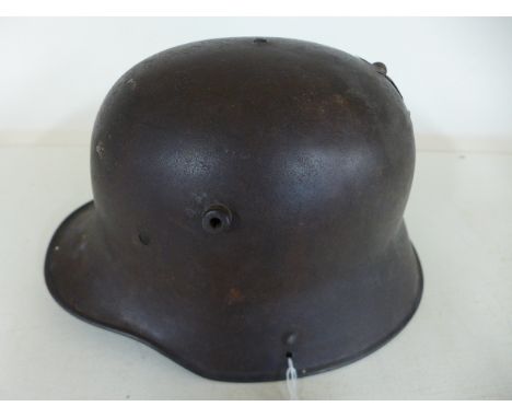 A World War I German helmet with added part cross to back Condition report: Drilled holes and missing liner 