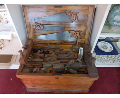A carpenters wooden vintage toolbox, items include three saws, plains, chisels, screwdrivers, drill bits and other tools, som