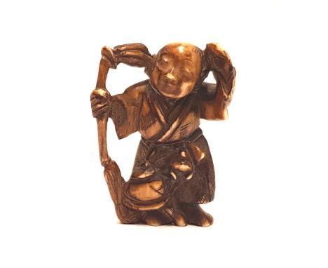 A carved ivory Meiji period netsuke: in the form of a Japanese elder, 4cm in height. 