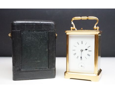 A antique gilt brass cased carriage clock, beveled glass panels, repeat and alarm movement, complete with key and outer case.