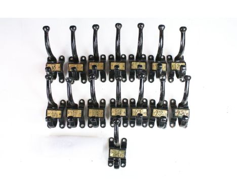 Set of fifteen vintage cast iron coat hooks with gold coloured numbering 