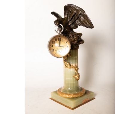 With a golden eagle holding a pocket watch perched on the capital of the column in onyx. Clock measures: 14 x 14 cm. Eagle me