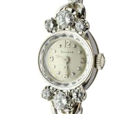 Bulova 14k White Gold and Diamond Case and Band Wristwatch  Bezel flanked on each side by three graduated round cut diamonds,