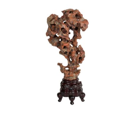 Chinese Scholar's Stone  Pierced and weathered stone having light crystalline inclusions in a reddish matrix, supported on a 