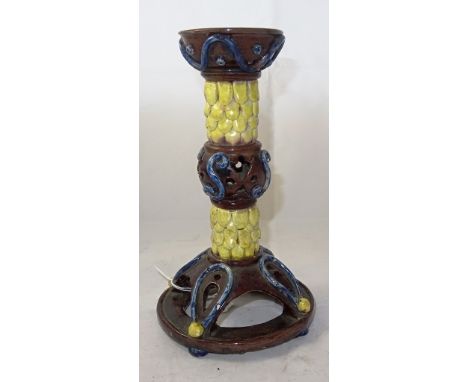 A Castle Hedingham pottery candlestick: With 'pineapple' knopped stem and pierced brown base decorated overall with blue scro