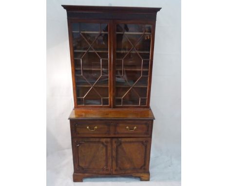 A 19th century mahogany secretaire bookcase: The dentil cornice above a blind fret cut frieze and astragal moulded glazed doo