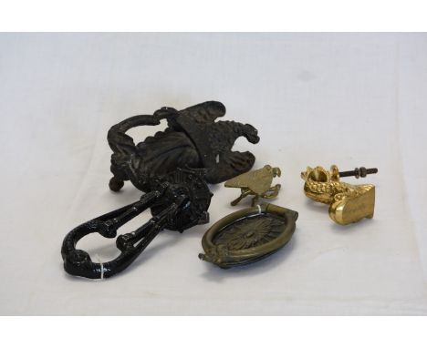 A wrought iron door knocker with eagle form finial.  A black painted door knocker. A brass door knocker in the form of a dolp