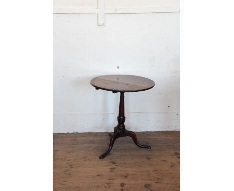 A Georgian oak tripod table with circular top on turned stem, tripod legs and pad feet.  23½ins diameter.  