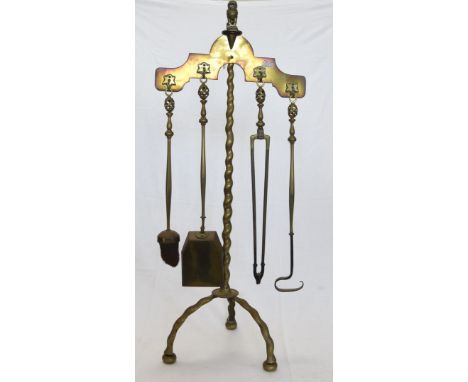 A brass fireside companion set stand with lion form finial, brush, shovel, tongs and poker with pierced swirl decorated finia