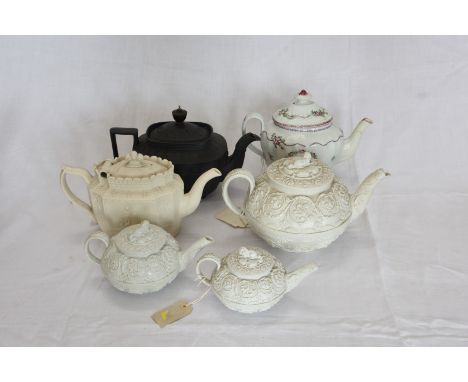 A black basalt teapot and cover.  A Wedgwood teapot and cover with dog form finial and scroll decoration.  A Castleford teapo