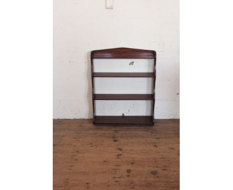 A mahogany hanging wall shelf with four shelves on shaped end supports.  25¼ins wide.  