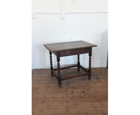 An 18th century oak side table with carved frieze, lunette carved frieze drawer, bobbin turned legs, flattened stretchers and