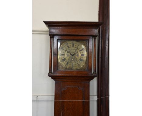 An 18th century oak cased longcase clock, the hood with stepped pediment above turned pilasters, the 12ins dial with pierced 