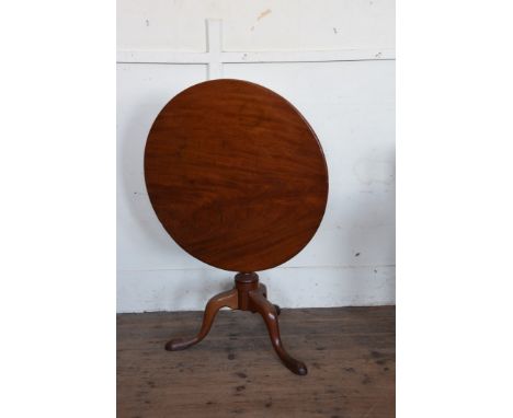 A George III mahogany tripod table with circular folding top, turned and gadrooned stem on tripod legs and pad feet.  32¼ins 