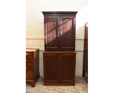 A Victorian and later mahogany cupboard with two panelled cupboard doors opening to reveal three adjustable sliding shelves a