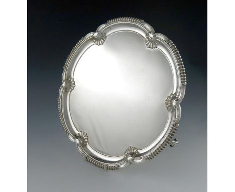 A silver salver, by Elkington and Co, Birmingham 1937, shaped circular form, with shell motifs and gadroon border, on three b