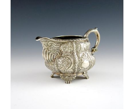 A George IV Irish silver cream jug, by Edward Crofton, Dublin 1823, circular baluster form, chased foliate scroll decoration 
