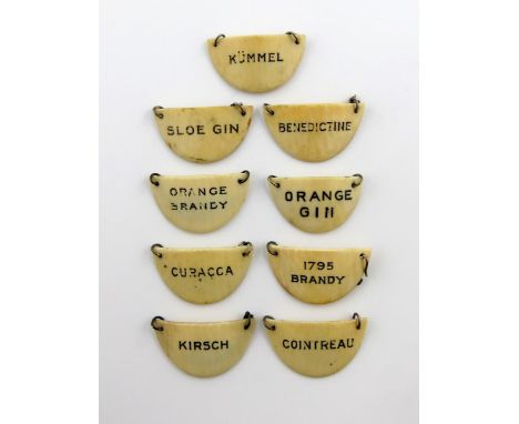 λA set of nine ivory liqueur labels, circa 1920, semi-circular form, titled 'ORANGE BRANDY', 'BENEDICTINE', 'SLOE GIN', '1795