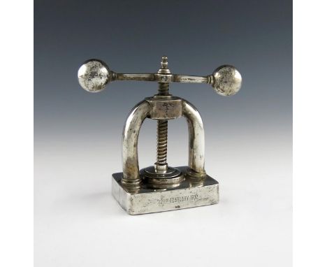 A silver nut cracker, marked STG SIL and an 8, a crown and lion, possibly Australian or Canadian, modelled as a press, dated 
