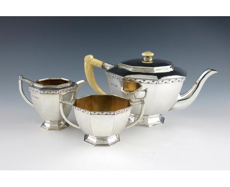 λBy R. E. Stone, a three-piece Art Deco silver tea set, London 1935, also signed 'R. E. Stone', octagonal tapering form, scro