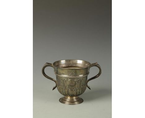 A GEORGE II TWO-HANDLED CUP of circular tapering form with "S"-shaped handles, part-fluted decoration and vacant circular car