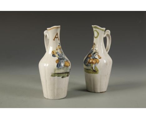 A PAIR OF ITALIAN MAIOLICA OIL AND VINEGAR JUGS of Castelli type, with painted figures playing musical instruments, 18th cent