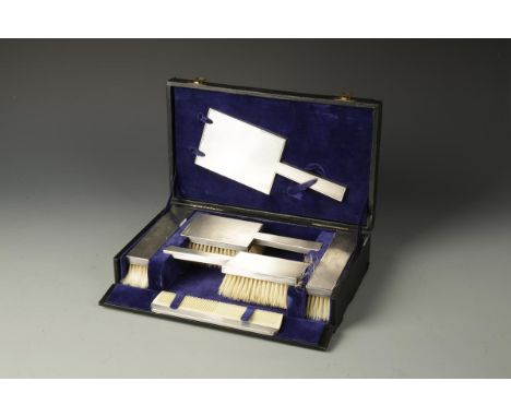 A CASED SILVER MOUNTED DRESSING TABLE SET with engine-turned decoration, in a fitted Harrods case, London 1946, the case 12" 