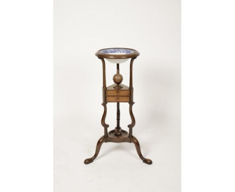 A GEORGE III MAHOGANY BASIN STAND, the circular dished top above two triangular drawers on scrolling downswept legs, with blu