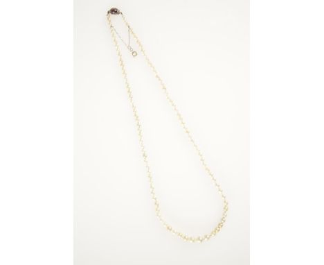 A SINGLE ROW NATURAL PEARL NECKLACE graduated from the front with a ruby and diamond cluster clasp. See illustration Accompan