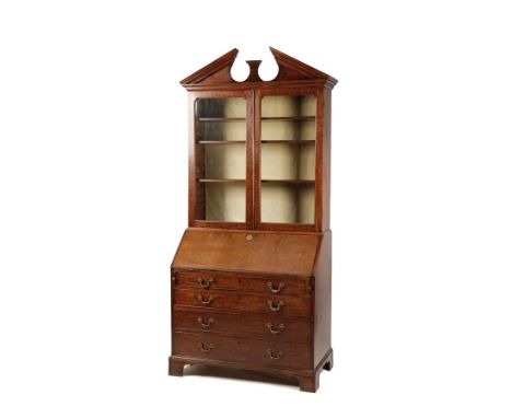 A GEORGE III MAHOGANY BUREAU BOOKCASE, the upper section with glazed doors enclosing a shelved interior, surmounted by a brok